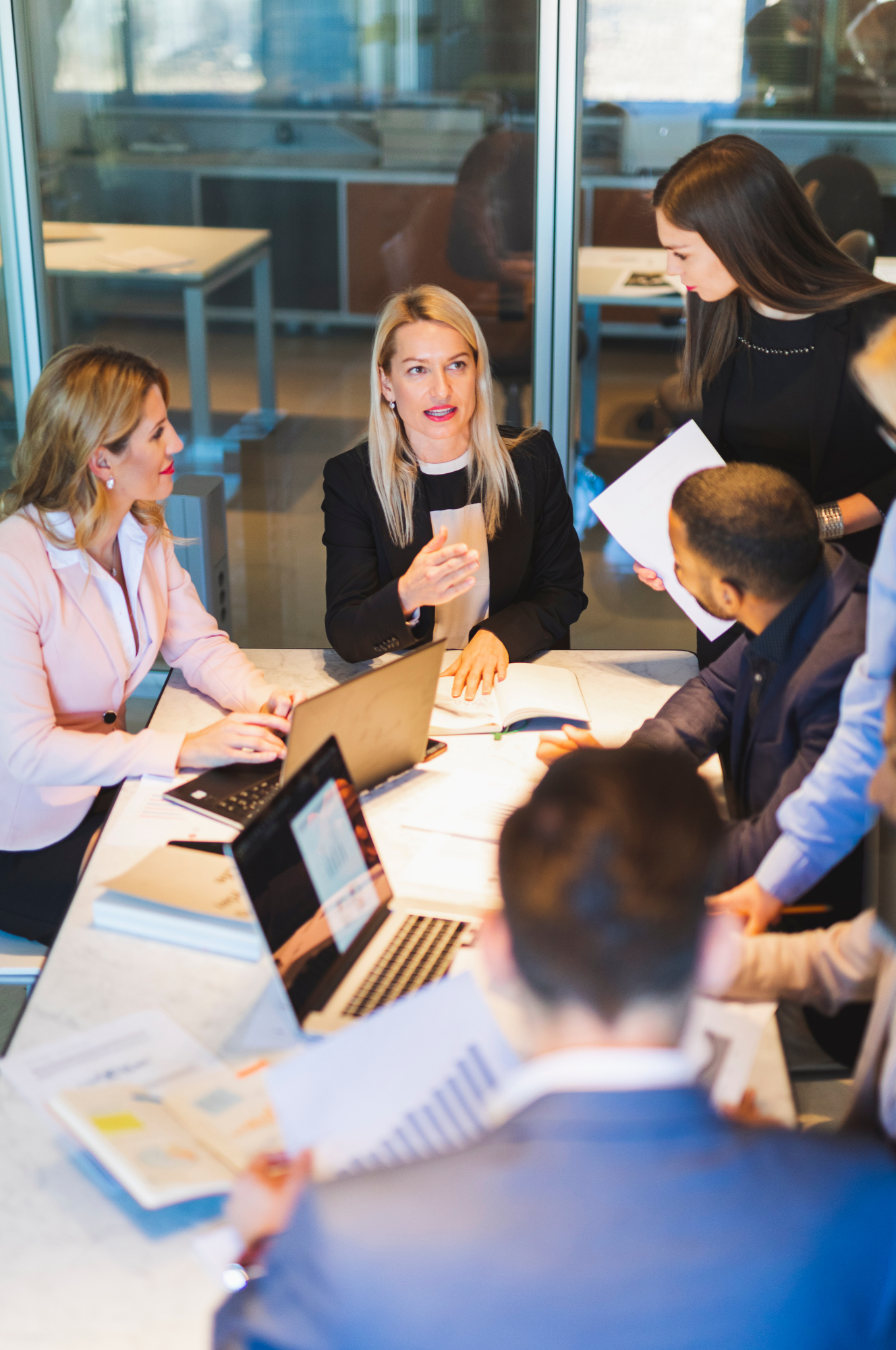Team Development Powered by Leadership Accelence with Accelus Partners, Texas leadership experts, coaches and speakers. - group of professionals meeting an a conference table.